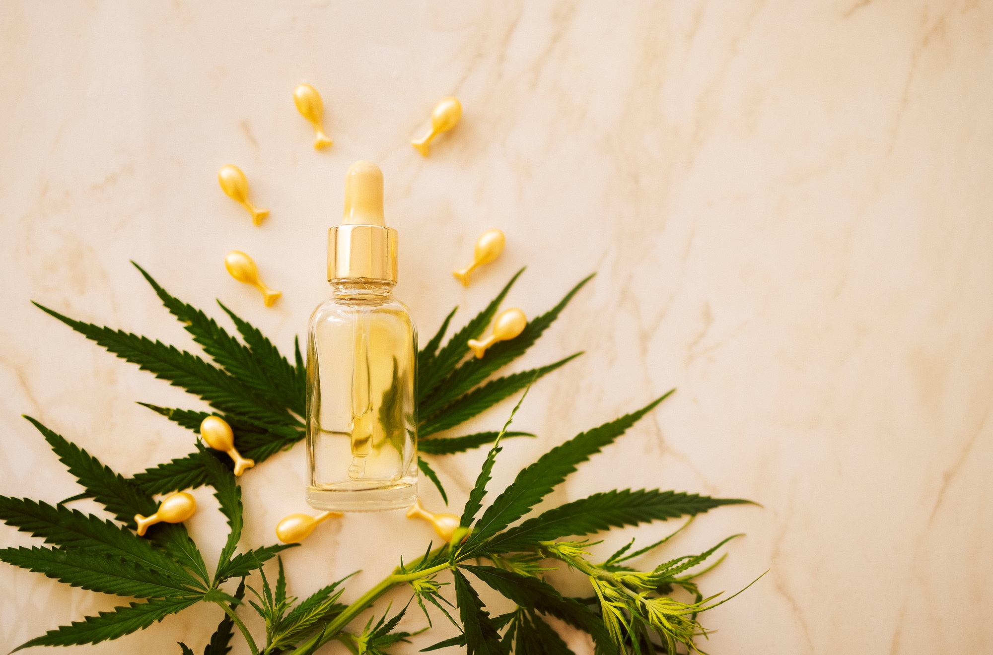 Mockup bottle cosmetic product with cannabis leaves on beige background